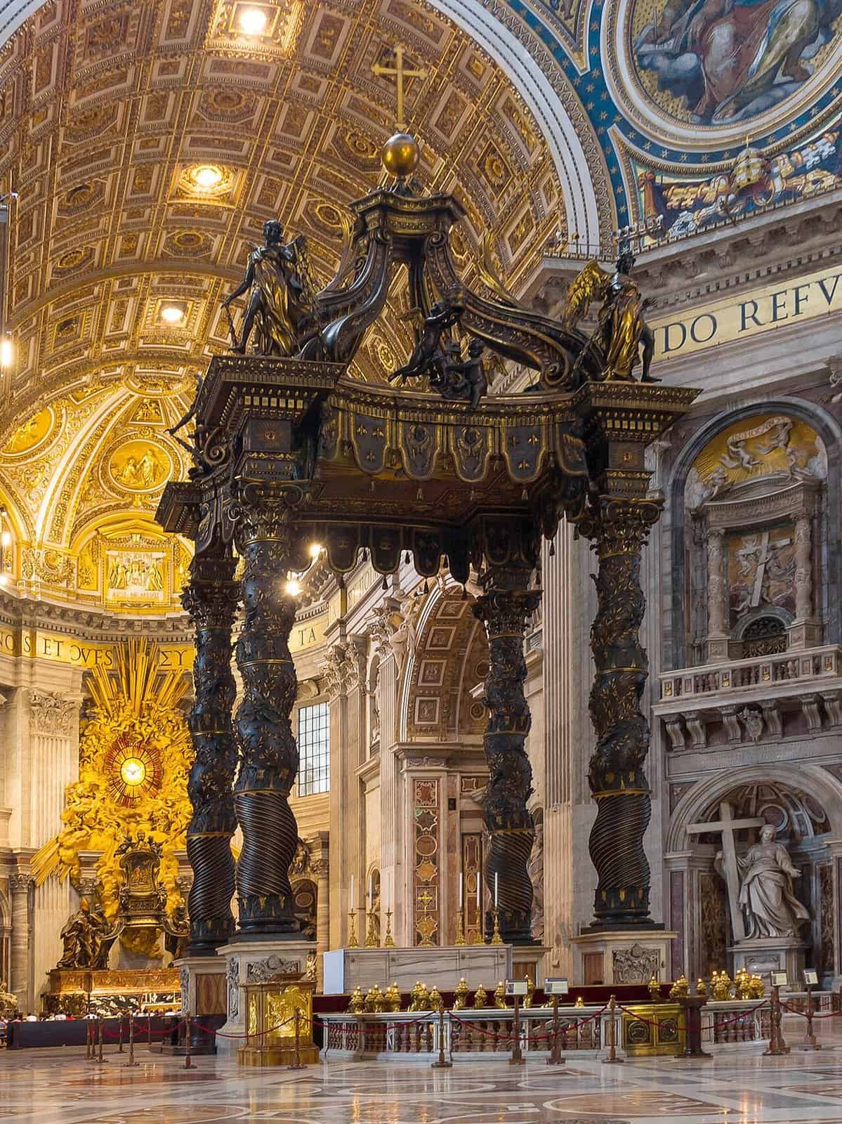 Bernini's bronze Baldacchino in St Peter's Basilica, with four twisted dark bronze columns rising to a canopy of angels and scrolls, and the gilded apse beyond