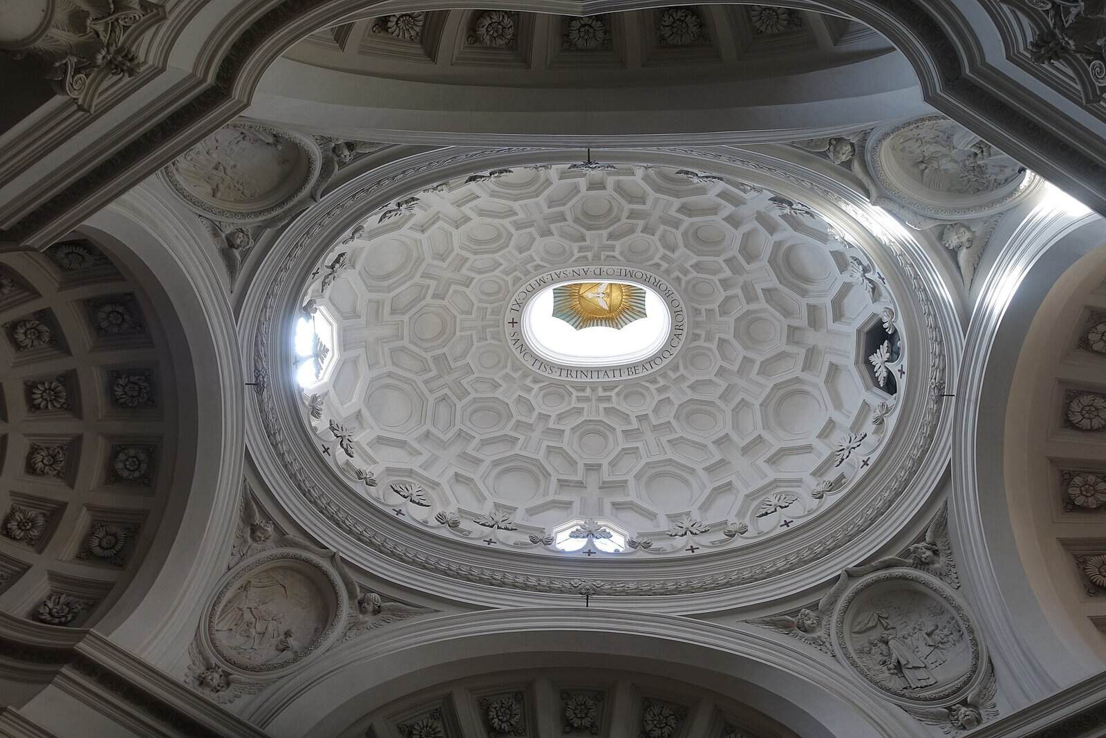 Looking up into the white oval dome of San Carlo alle Quattro Fontane in Rome, with crosses, octagons and hexagons in the coffering shrinking towards a bright lantern