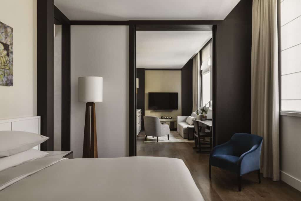 Capella Sydney bedroom looking through a dark timber portal into the suite living area