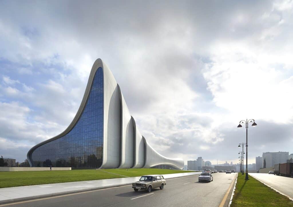 Street-level view of the Heydar Aliyev Center glass facade and soaring white curves