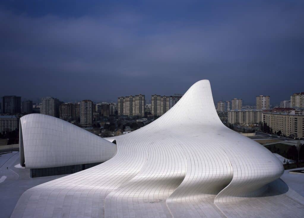 High-angle view of the Heydar Aliyev Center twin peaks over the plaza toward Baku