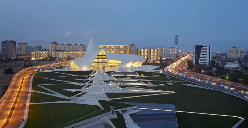 Aerial dusk view of the Heydar Aliyev Center amid folded landscape paths and highways