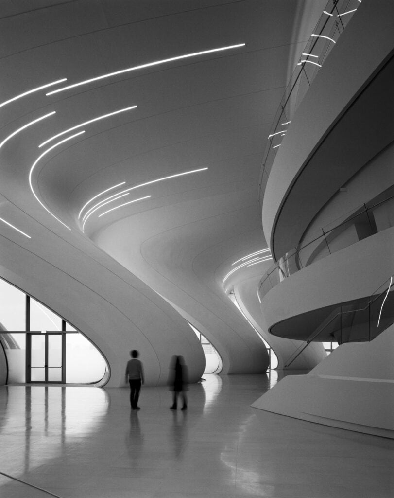 Black-and-white view of flowing white atrium vaults and balconies inside the Heydar Aliyev Center