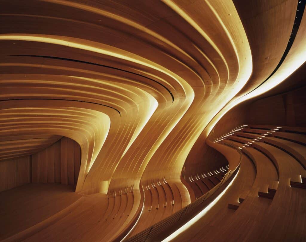 Empty oak auditorium floor curving into seating and ceiling waves at the Heydar Aliyev Center