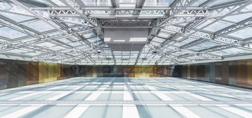 Event pavilion on the roof of Il Fondaco dei Tedeschi, a wide glass floor glowing beneath a steel-trussed glazed roof, its walls lined with panels in gold, bronze and grey tones