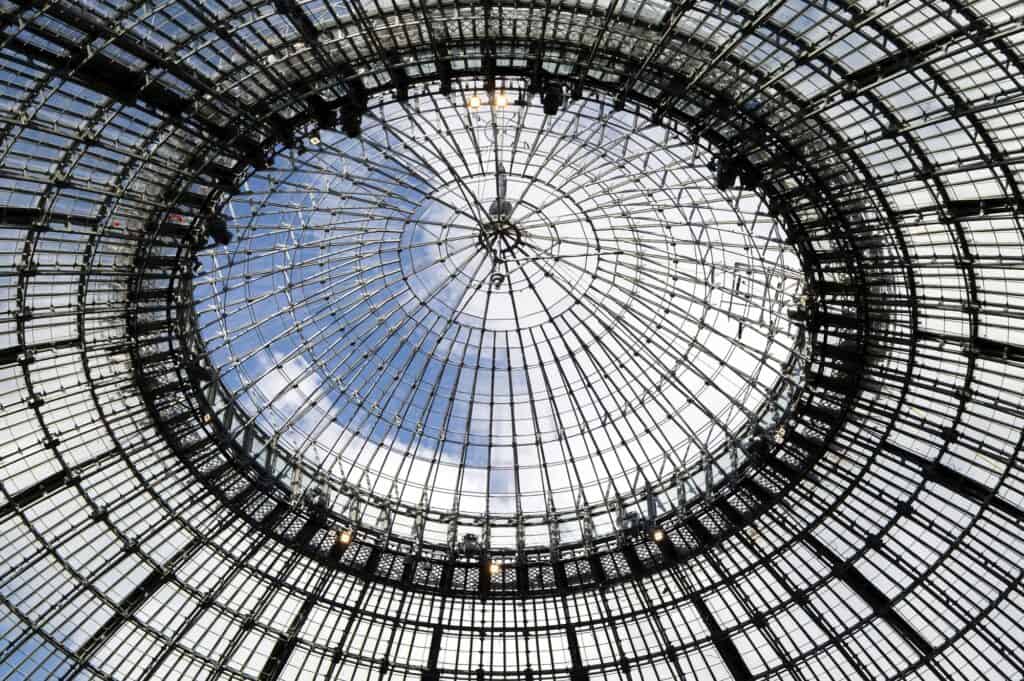 Cast-iron and glass dome of La Bourse de Commerce seen from below against the sky