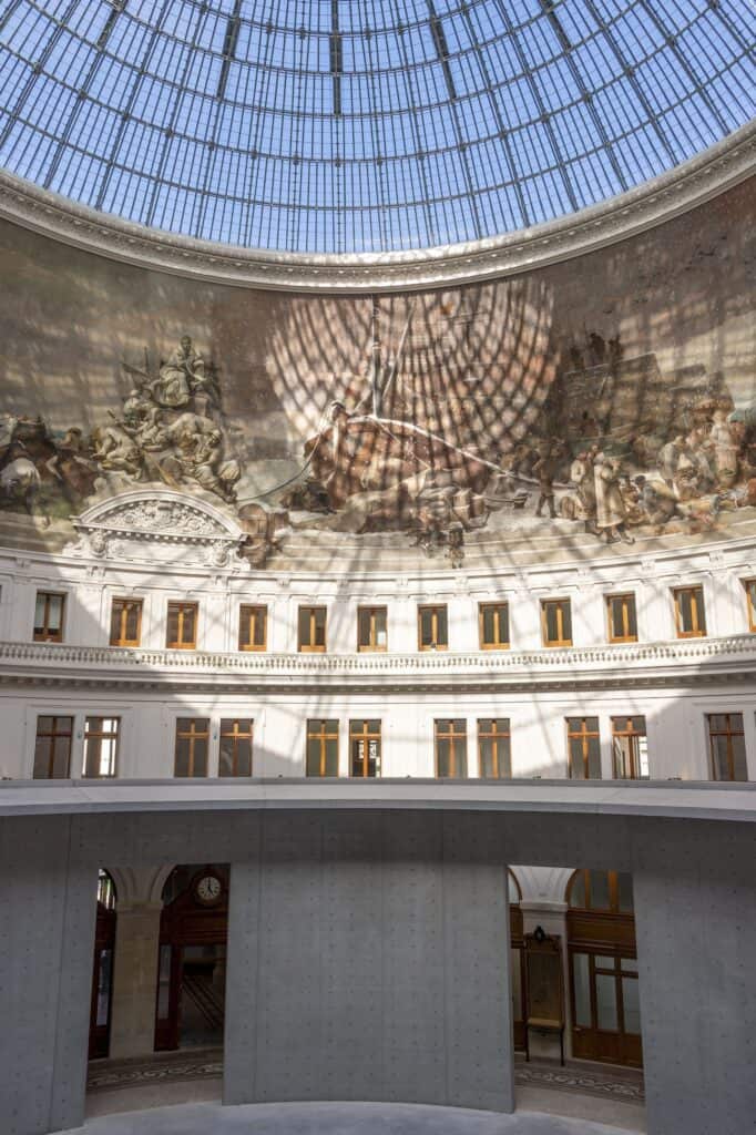 Rotunda of La Bourse de Commerce with dome mural and concrete cylinder, seen from the upper level