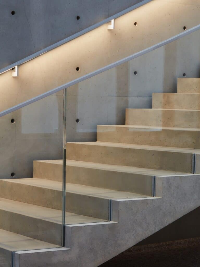 Concrete staircase with glass balustrade and recessed lighting inside La Bourse de Commerce