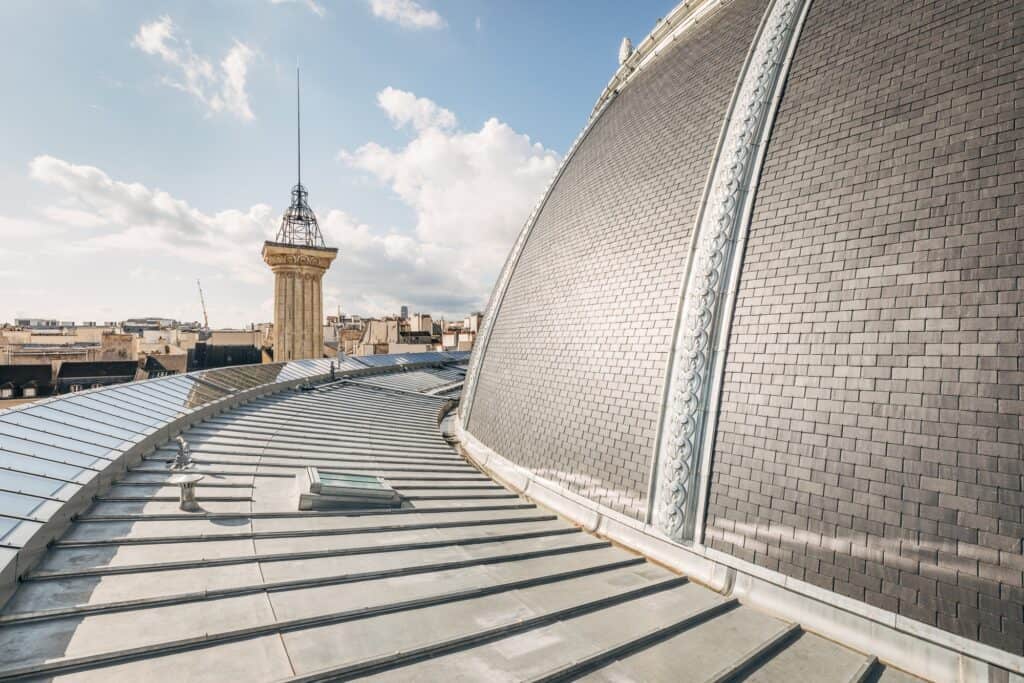 Restored slate roof and dome of La Bourse de Commerce with the Saint-Eustache lookout tower beyond