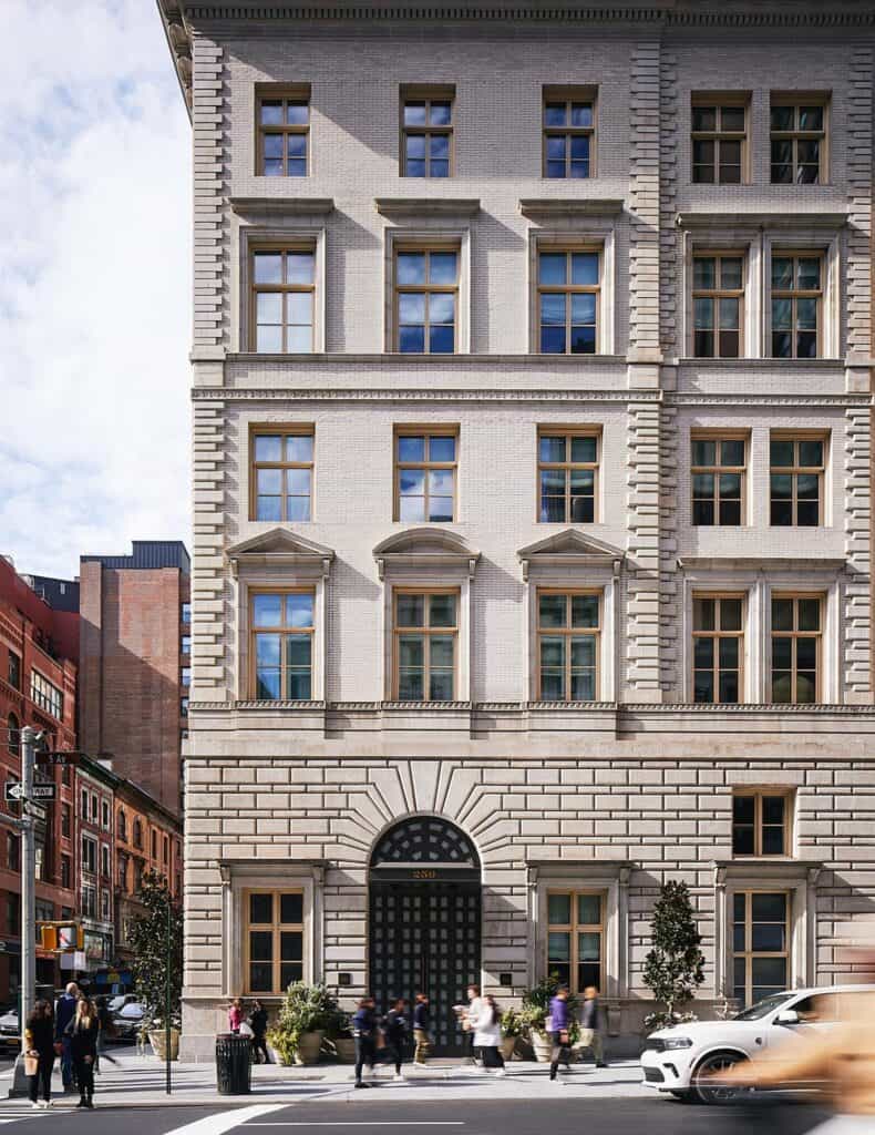The Fifth Avenue Hotel in New York, McKim, Mead & White's 1907 limestone Renaissance palazzo on Fifth Avenue with pedimented windows, a rusticated base and an arched iron entrance