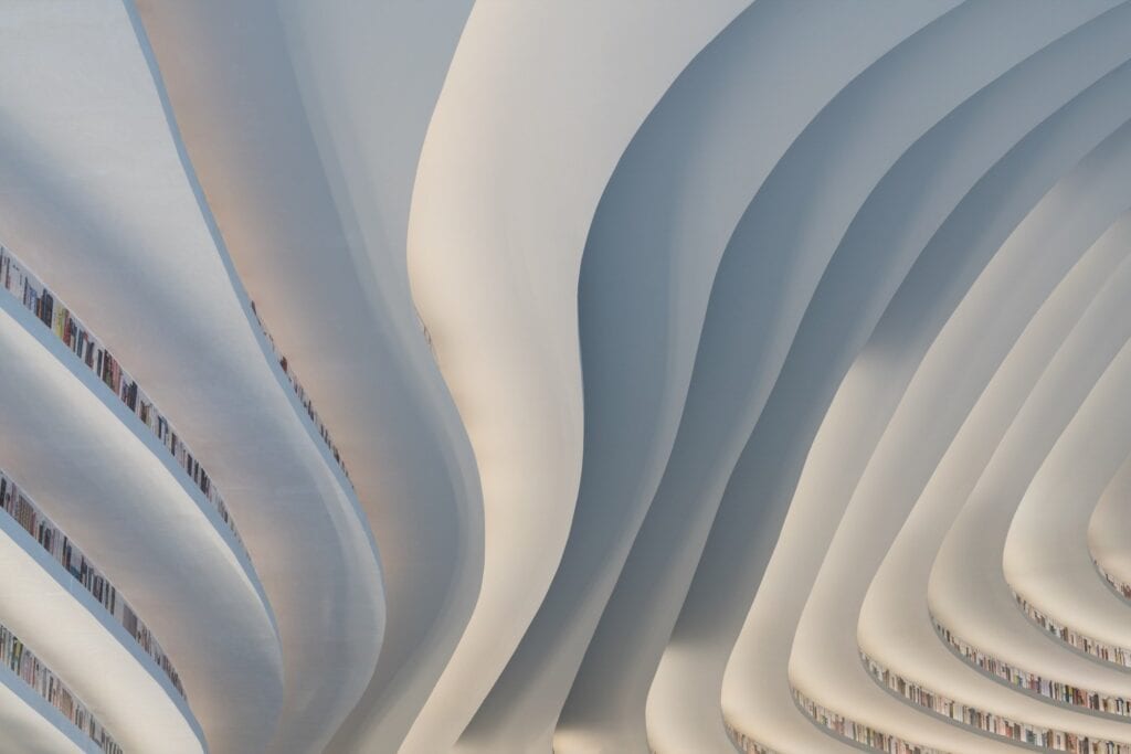 Close-up of undulating white ceiling layers edged with books at Tianjin Binhai Library